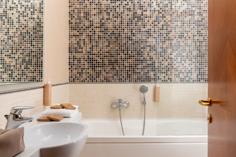 Bathroom with bathtub and mosaic tiling, amenities set and clean lines for comfort in Sarzana, Liguria - Sarzana Park Hotel, BZAR hotels in Liguria