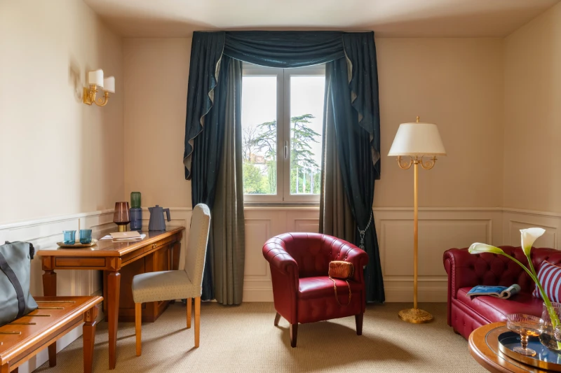 In-room lounge with red leather armchair, desk and warm lighting for relaxation in Sarzana, Liguria - Sarzana Park Hotel, BZAR hotels in Liguria